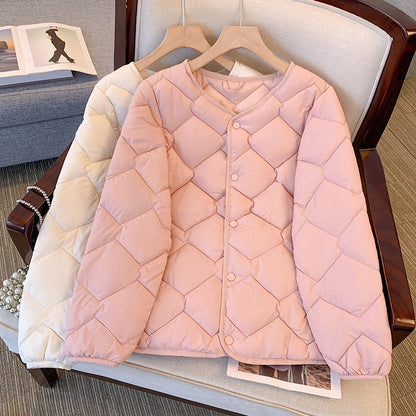 Giacca trapuntata rosa chiaro su sedia, design a rombi, bottoni frontali, accanto a giacca bianca. Moda autunnale, abbigliamento casual elegante.