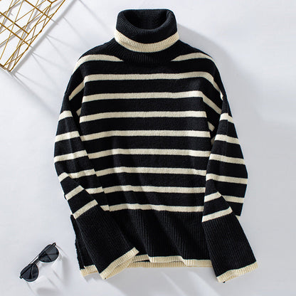 Maglione a righe bianche e nere con collo alto, stile casual, su sfondo bianco. Occhiali da sole neri accanto. Moda autunnale, abbigliamento invernale.