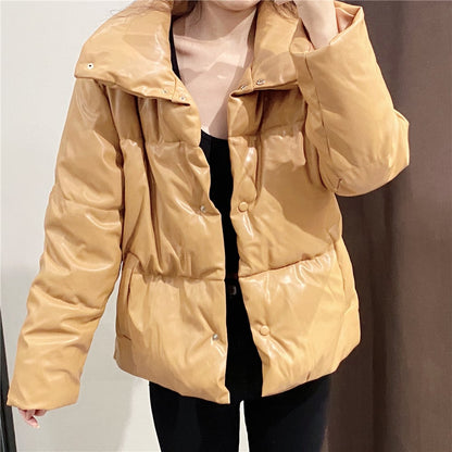 Giacca imbottita marrone chiaro lucida, indossata da una persona. Moda invernale, stile casual, abbigliamento caldo e confortevole.