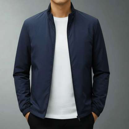 Giacca blu scuro da uomo, stile casual, con zip frontale, indossata su maglietta bianca. Moda maschile, abbigliamento autunnale elegante.