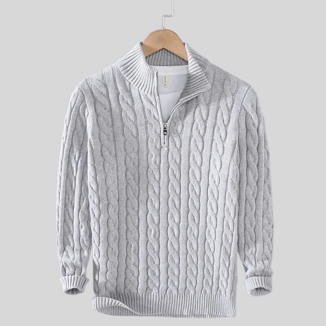 Maglione grigio a trecce con zip, collo alto, su gruccia. Elegante e caldo, ideale per moda invernale e abbigliamento casual.