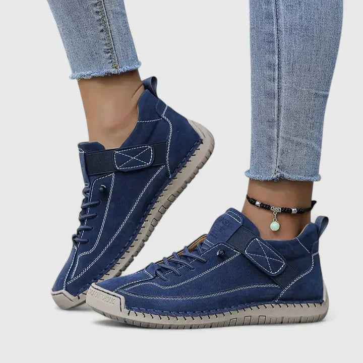 Scarpe da ginnastica blu da donna, design casual con suola in gomma antiscivolo, abbinate a jeans chiari. Stile moderno e confortevole.