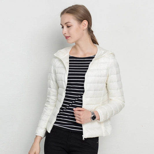 Giacca piumino bianco donna, indossata su maglia a righe nere e bianche. Moda autunno inverno, abbigliamento casual elegante.