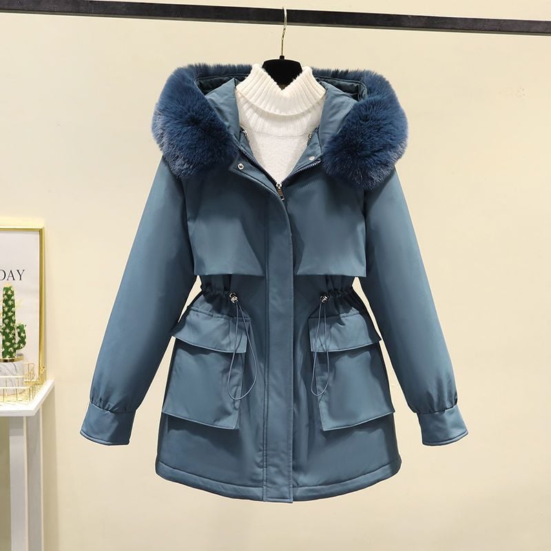 Giacca invernale blu con cappuccio in pelliccia sintetica, tasche frontali e chiusura a zip, appesa su gruccia. Elegante e calda per la stagione fredda.