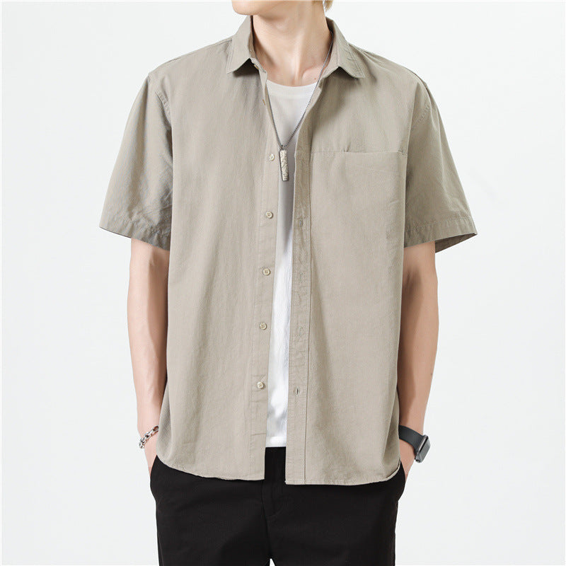 Camicia beige a maniche corte da uomo, stile casual, abbinata a t-shirt bianca e pantaloni neri. Moda estiva maschile, look moderno e minimalista.