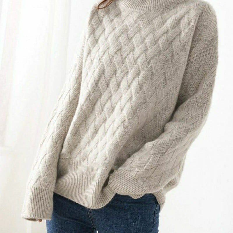 Maglione invernale beige a trecce, morbido e caldo, indossato con jeans blu. Stile casual, moda autunnale, abbigliamento donna elegante.