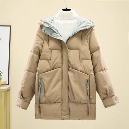 Giacca invernale imbottita beige con cappuccio, chiusura a zip, tasche frontali con cerniera, su sfondo neutro. Moda donna, abbigliamento caldo.