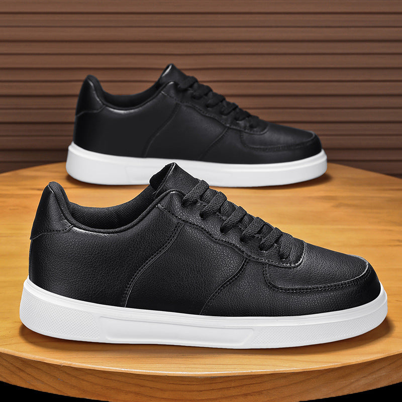 Scarpe da ginnastica nere in pelle con suola bianca su tavolo di legno, design moderno e casual, perfette per moda urbana e comfort quotidiano.