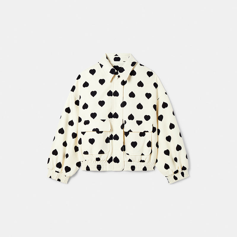 Giacca bianca con motivo a cuori neri, tasche frontali e chiusura a zip. Moda donna, abbigliamento casual, stile trendy e moderno.