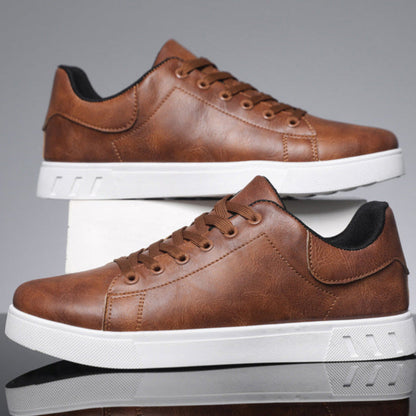 Scarpe da ginnastica in pelle marrone con suola bianca, design moderno e casual, perfette per look urbani e alla moda.