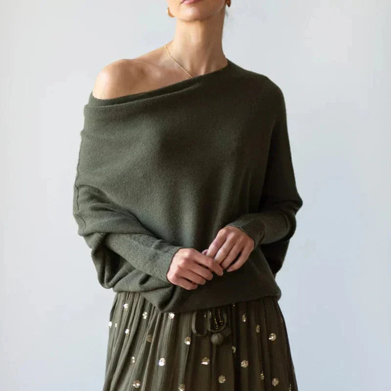 Donna con maglione verde oliva a spalla scoperta e gonna decorata con paillettes. Moda autunnale elegante, stile casual chic.