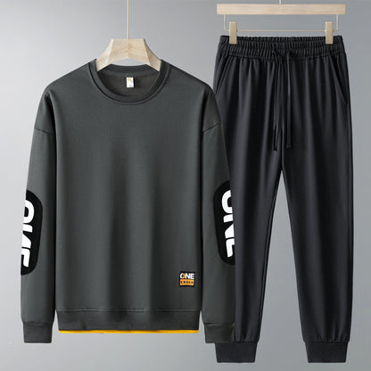 Completo tuta sportiva uomo grigio scuro, felpa e pantaloni con scritta "ONE" sulle maniche. Abbigliamento casual, moda uomo, stile urbano.