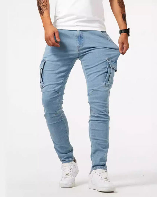Jeans cargo uomo azzurri, tasche laterali, indossati con sneakers bianche e t-shirt bianca. Stile casual, moda maschile contemporanea.