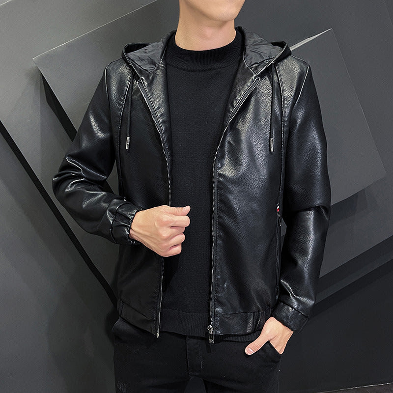 Giacca in pelle nera con cappuccio, indossata da uomo su sfondo geometrico grigio. Moda maschile, abbigliamento casual elegante.
