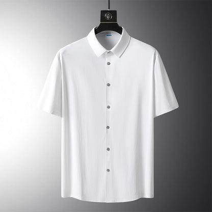 Camicia bianca a maniche corte su sfondo grigio, con colletto classico e bottoni frontali. Moda uomo, abbigliamento estivo elegante.