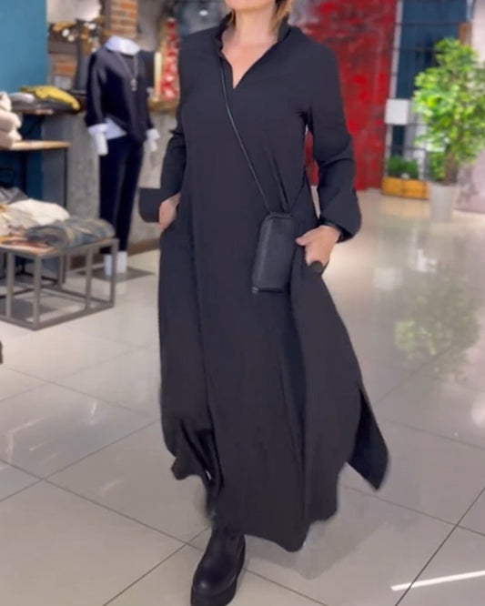 Donna in abito lungo nero con borsa a tracolla, in negozio di moda. Abbigliamento elegante, stile minimalista, tendenze moda 2023.