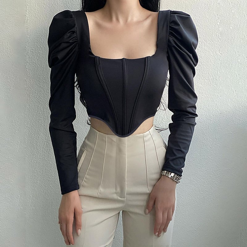 Donna con top nero a maniche lunghe e pantaloni beige, stile elegante e moderno. Moda femminile, abbigliamento trendy, outfit chic.