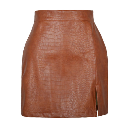 Gonna corta in ecopelle marrone con stampa coccodrillo, design a vita alta e spacco laterale. Moda donna, abbigliamento trendy autunno inverno.
