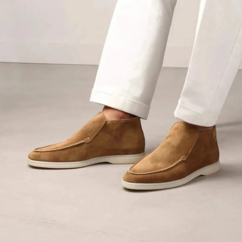 Scarpe uomo in camoscio marrone chiaro, design elegante, abbinate a pantaloni bianchi. Calzature moda autunno, stile casual chic.