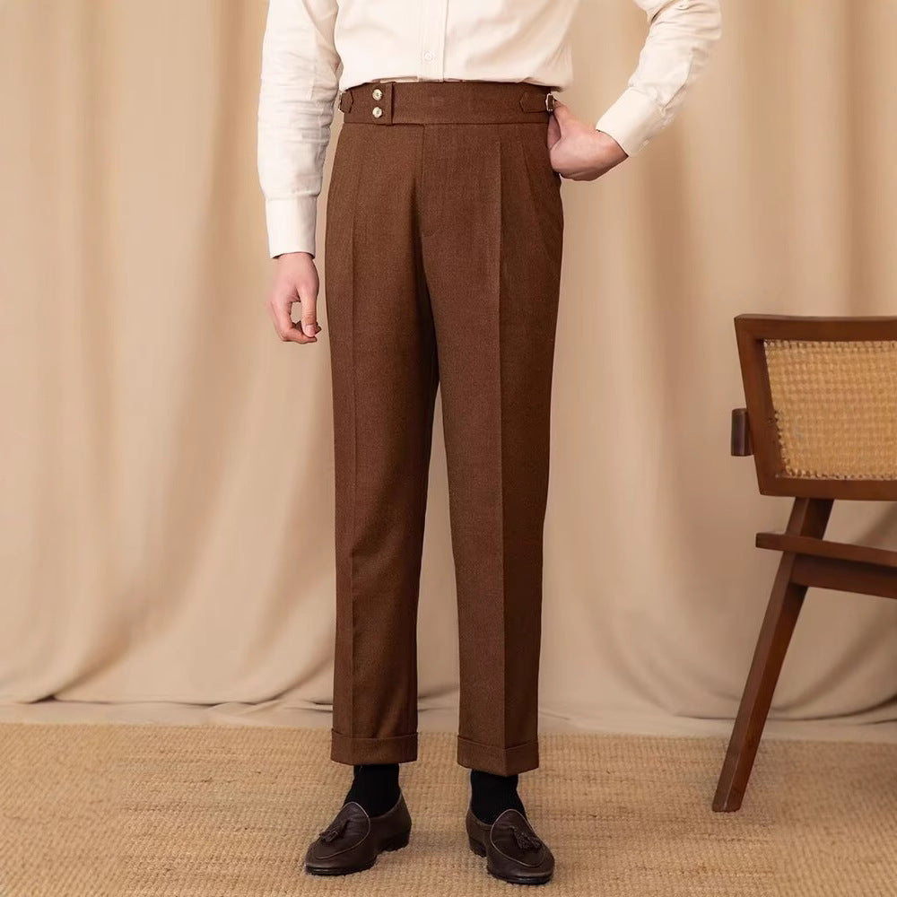 Uomo in pantaloni marroni eleganti, camicia bianca, scarpe classiche, sfondo beige. Moda maschile, abbigliamento formale, stile vintage.