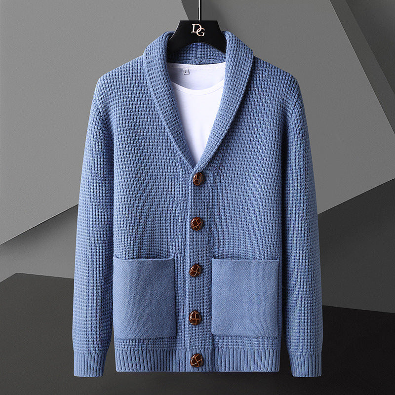 Cardigan blu in maglia a coste con bottoni marroni, tasche frontali e colletto a scialle, appeso su gruccia nera. Moda uomo elegante e casual.