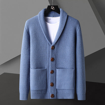 Cardigan blu in maglia a coste con bottoni marroni, tasche frontali e colletto a scialle, appeso su gruccia nera. Moda uomo elegante e casual.