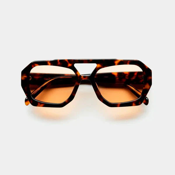 Occhiali da sole tartarugati con montatura geometrica e lenti marroni, design moderno. Accessorio moda unisex, stile retrò chic.