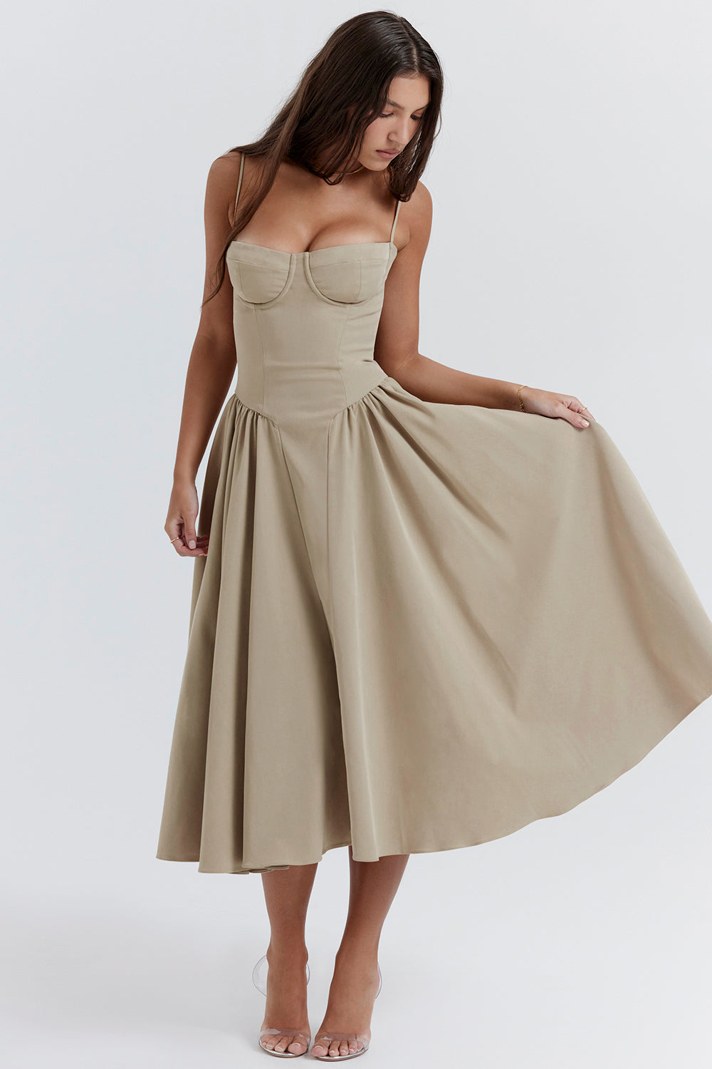 Donna con abito beige elegante, lungo e svasato, con spalline sottili. Moda femminile, abbigliamento estivo, stile sofisticato.