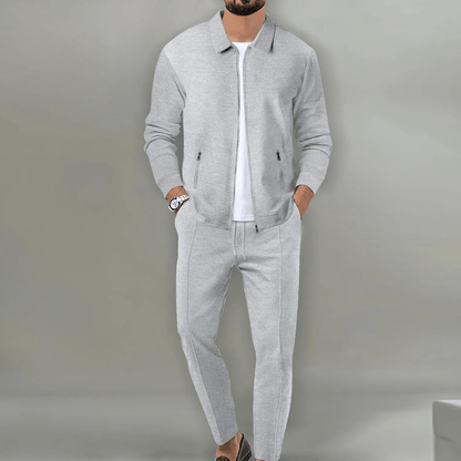 Giacca e pantaloni grigi eleganti da uomo, abbinati a una maglietta bianca e orologio. Moda maschile casual, stile moderno e sofisticato.