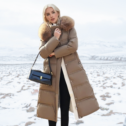 Donna in cappotto invernale marrone con cappuccio in pelliccia, borsa nera, paesaggio innevato. Moda invernale, abbigliamento caldo, stile elegante.