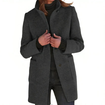 Cappotto donna invernale grigio scuro, elegante e caldo, con tasche frontali e chiusura a bottoni. Ideale per moda autunno-inverno.