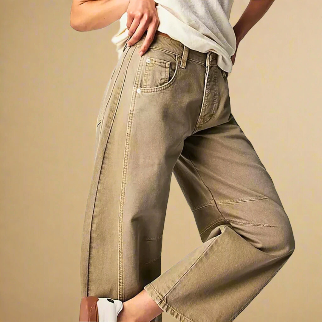 Jeans beige a gamba larga da donna, stile casual, abbinati a una maglietta bianca e scarpe da ginnastica bianche, moda femminile contemporanea.