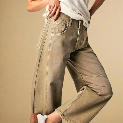 Jeans beige a gamba larga da donna, stile casual, abbinati a una maglietta bianca e scarpe da ginnastica bianche, moda femminile contemporanea.