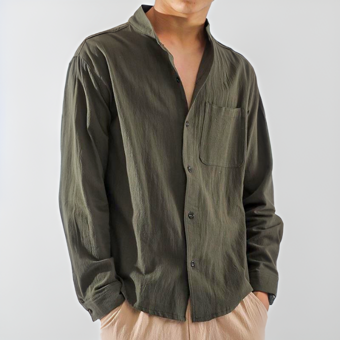 Camicia verde oliva da uomo con colletto alla coreana, maniche lunghe e taschino, abbinata a pantaloni beige. Stile casual ed elegante.