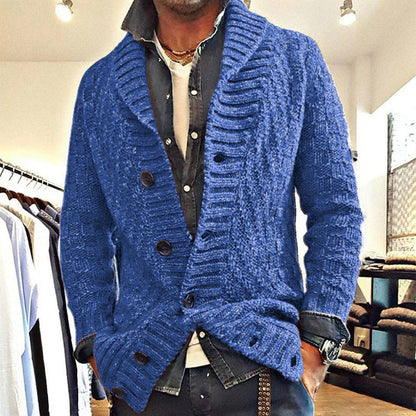 Uomo con cardigan blu a maglia grossa, indossato sopra camicia e jeans, in negozio di abbigliamento. Moda maschile, stile casual elegante.