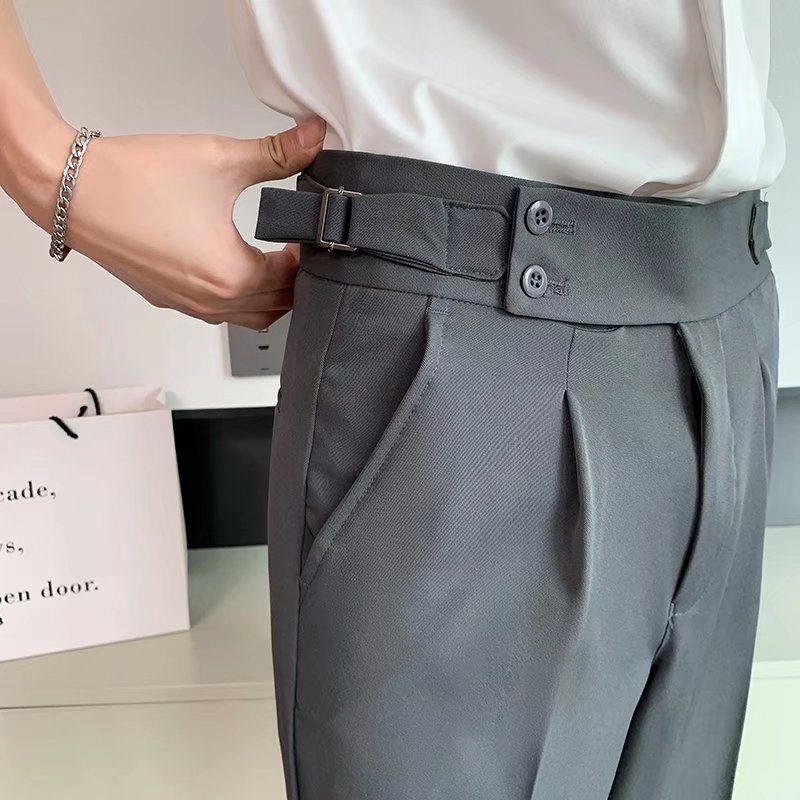 Pantaloni eleganti grigi con cintura regolabile, indossati da una persona in camicia bianca. Stile moderno, moda uomo, abbigliamento formale.