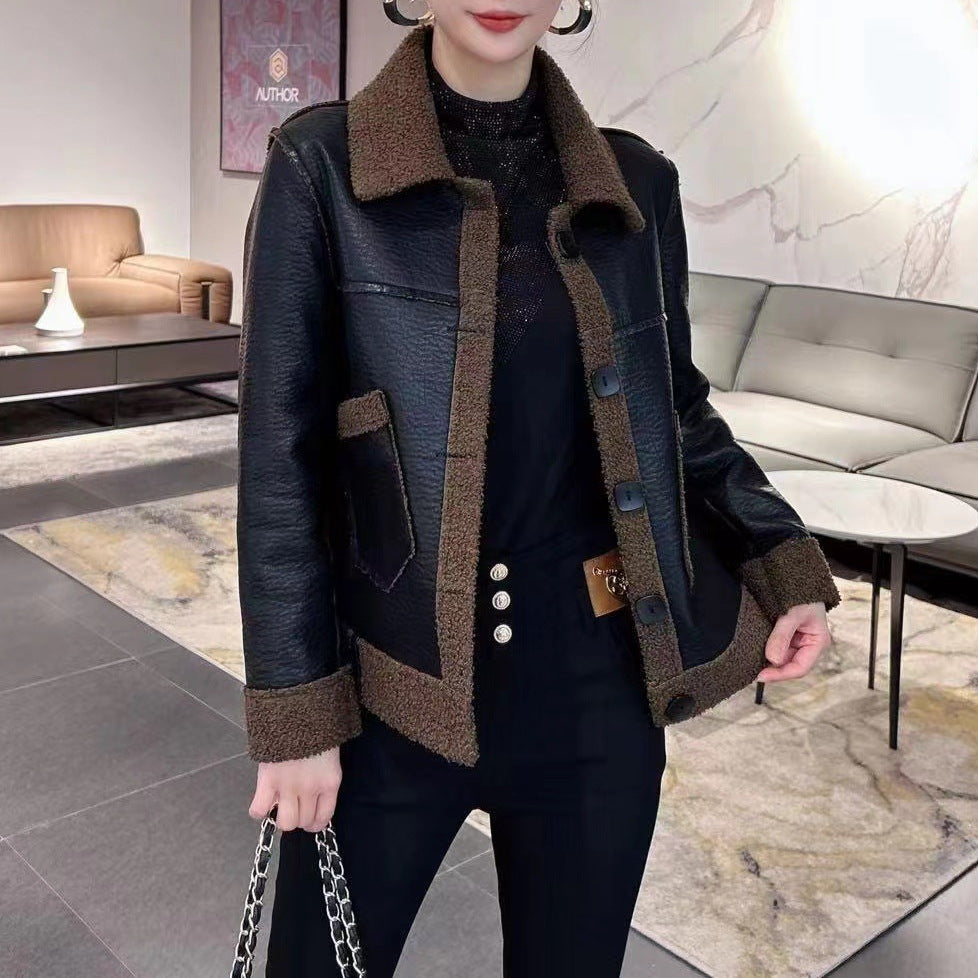 Giacca in pelle nera con dettagli in pelliccia marrone, indossata da una donna in un salotto moderno. Moda autunno inverno, abbigliamento elegante.