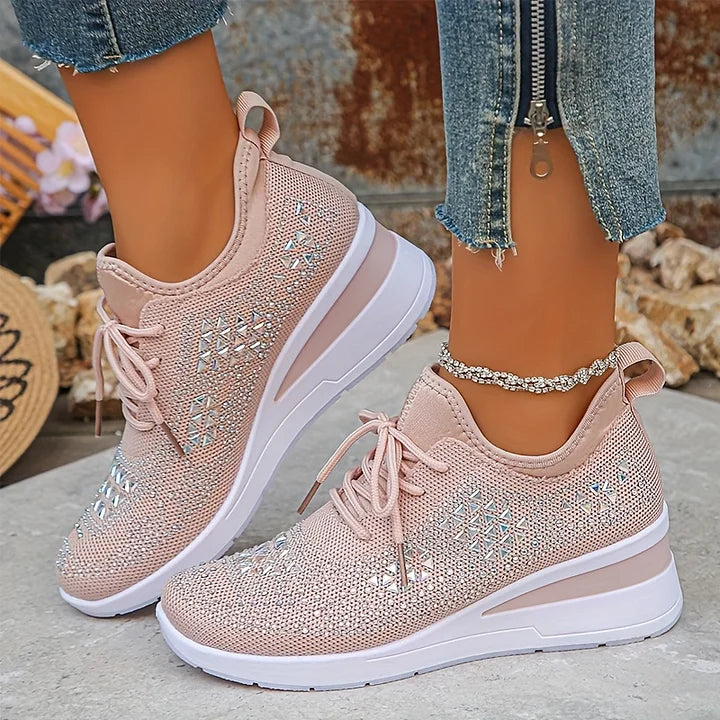 Scarpe da ginnastica rosa con zeppa, dettagli brillanti, indossate con jeans strappati. Scarpe moda donna, comode e trendy per look casual.