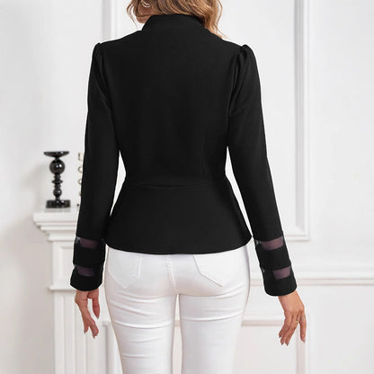 Giacca nera elegante da donna vista posteriore, dettagli trasparenti sulle maniche, abbinata a pantaloni bianchi, moda femminile contemporanea.