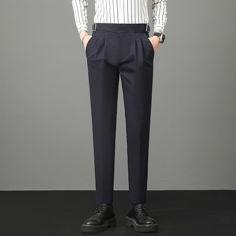 Pantaloni eleganti uomo blu scuro, abbinati a camicia a righe bianche e nere, scarpe nere. Moda maschile, abbigliamento formale.
