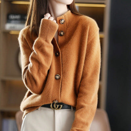 Donna con cardigan marrone in cashmere, bottoni in legno, cintura nera con fibbia dorata, sfondo sfocato. Moda autunnale elegante.