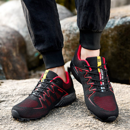 Scarpe da trekking nere e rosse su terreno roccioso, design sportivo e resistente, ideali per escursioni all'aperto. Scarpe outdoor uomo.