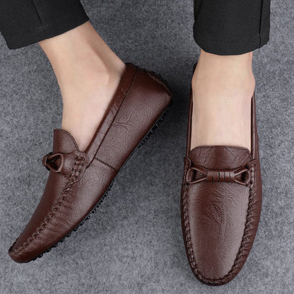 Mocassini uomo in pelle marrone, eleganti e comodi, su sfondo grigio. Scarpe casual perfette per look formale e quotidiano.