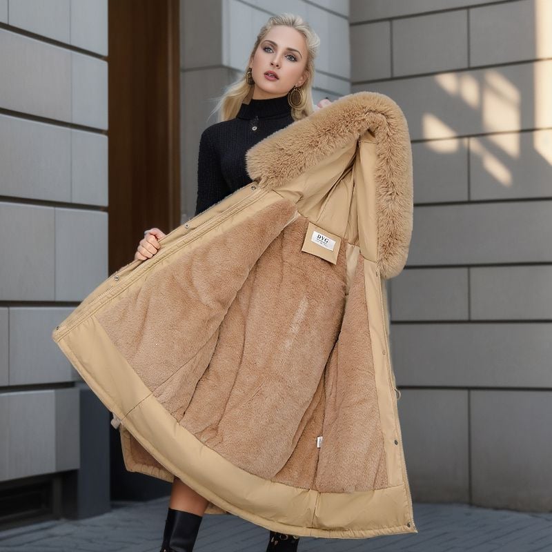 Donna con cappotto invernale beige con interno in pelliccia sintetica, sfondo urbano. Moda femminile, abbigliamento caldo, stile elegante.