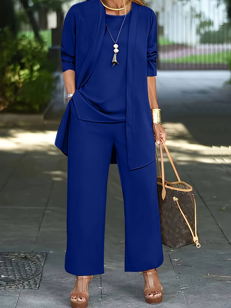 Donna in elegante completo blu, giacca e pantaloni larghi, con borsa di lusso marrone. Look estivo chic, moda femminile, outfit casual sofisticato.