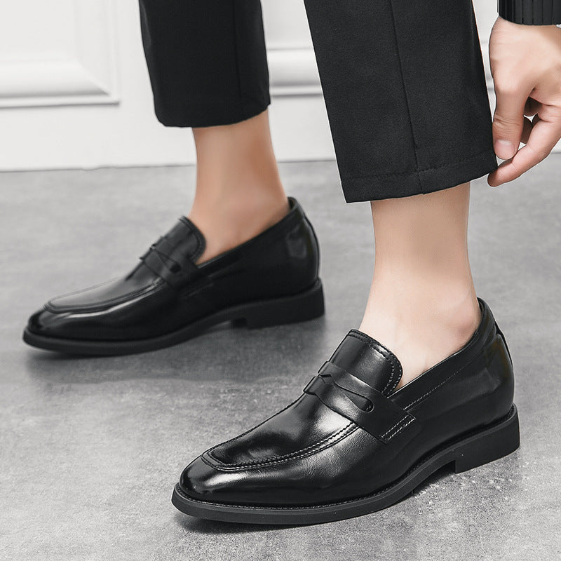 Scarpe eleganti uomo in pelle nera, mocassini lucidi, indossati con pantaloni neri su pavimento grigio. Moda maschile, calzature formali.