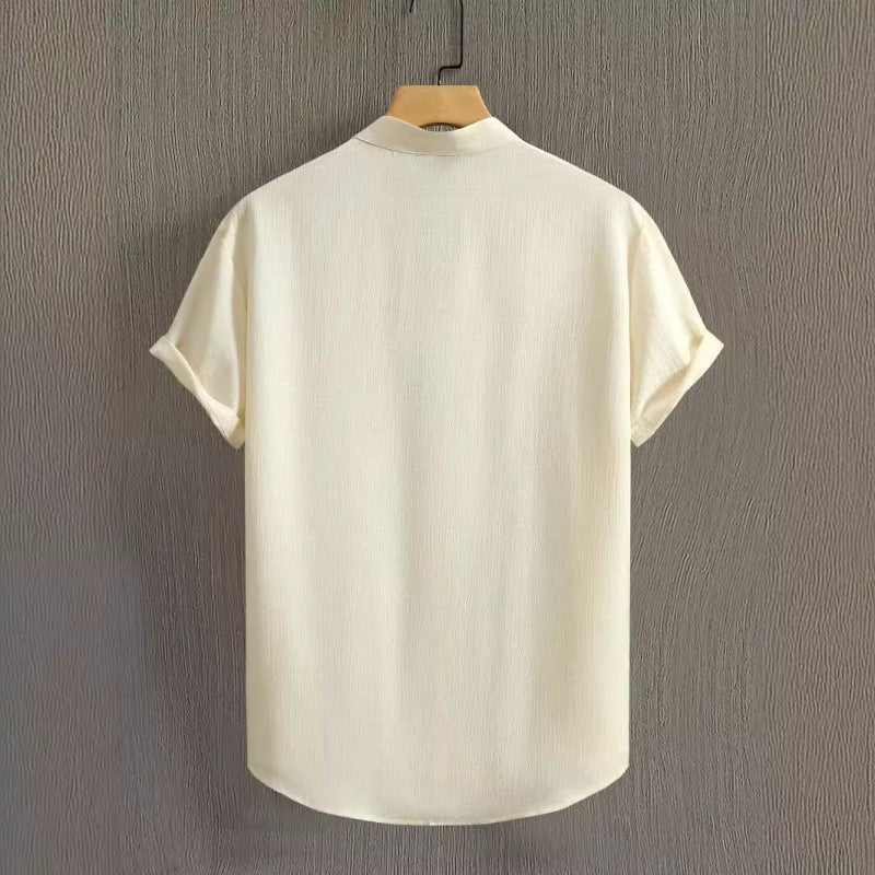 Camicia bianca a maniche corte in lino, vista posteriore, appesa su gruccia. Design minimalista, ideale per look estivi casual ed eleganti.