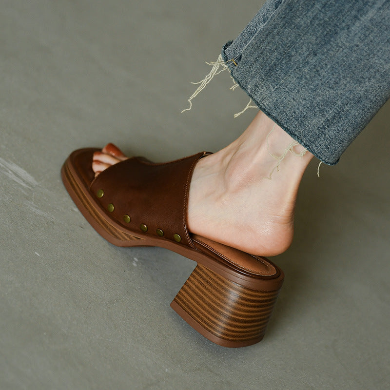Sandalo marrone con tacco largo in legno, indossato con jeans strappati. Moda estiva, calzature eleganti, stile casual chic.