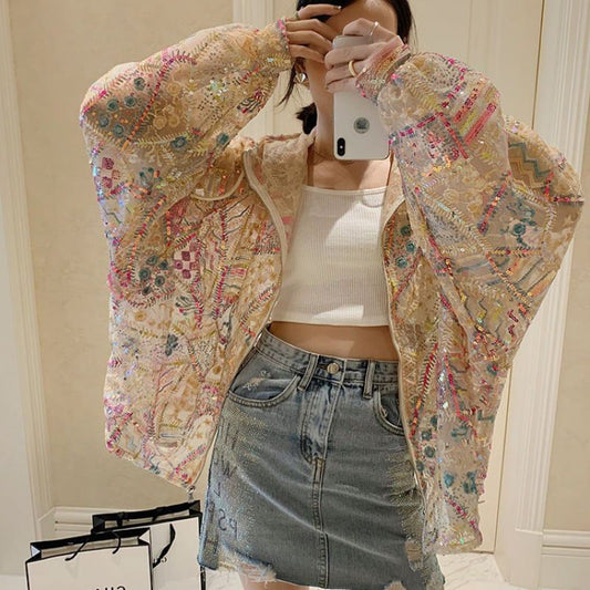 Giacca ricamata colorata indossata da donna con top bianco e gonna di jeans. Moda femminile, abbigliamento casual, stile trendy.