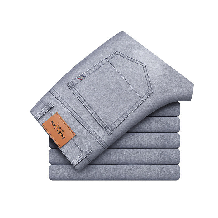 Jeans grigi piegati, tasca posteriore visibile, etichetta in pelle marrone. Moda uomo, abbigliamento casual, tessuto denim di alta qualità.